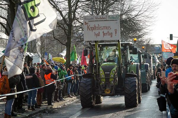 Foto: © heba / Umbruch Bildarchiv Treckerkolonne fährt durch die Demonstration. Der erste hat ein Plakat auf der Gabel: "Klimawandel? Artensterben? Plastikmüll? Kapitalismus hat fertig!"