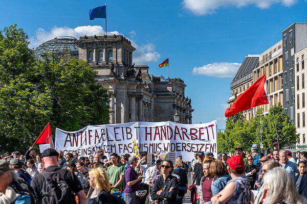 Das Foto zeigt die Demo am Reichstag mit dem Hochtransparent: "Antifa bleibt Handarbeit - Gemeinsam dem Faschismus widersetzen!" sowie zahlreichen Demonstrant:*Innen