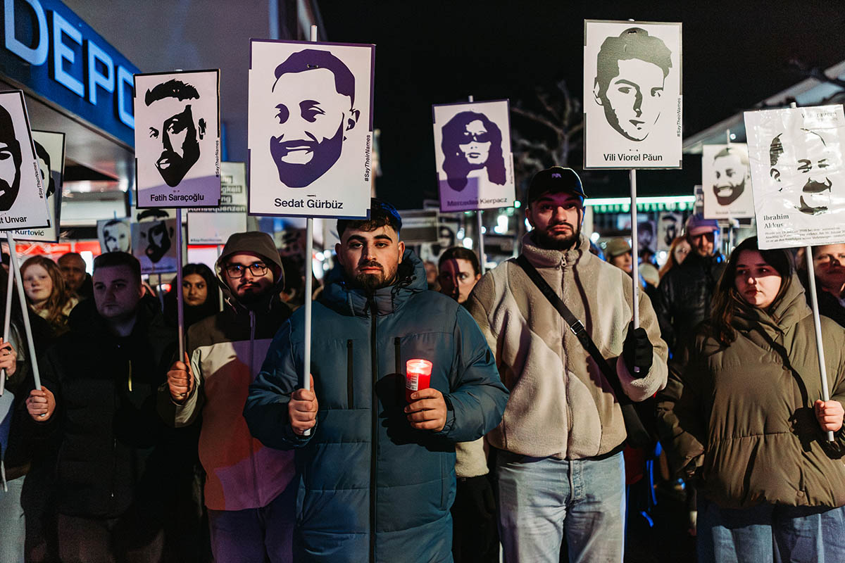 Das Foto von © Protestfotografie.Frankfurt zeigt eine Reihe Teilnehmer* der Gedenkaktionen mit Porträts der Ermeordeten und deren Namen