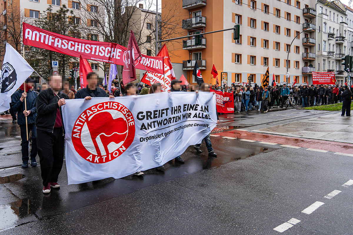 Das Foto von © Björn Obmann zeigt das Fronttransparent mit dem historischen Logo der Antifaschistischen Aktion und dem Text: "Greift Ihr eine an antworten wir alle! - Organisiert gegen faschistische Gewalt". Dahinter sind weitere Transparente zu sehen sowie viele Demoteilnehmer:*Innen
