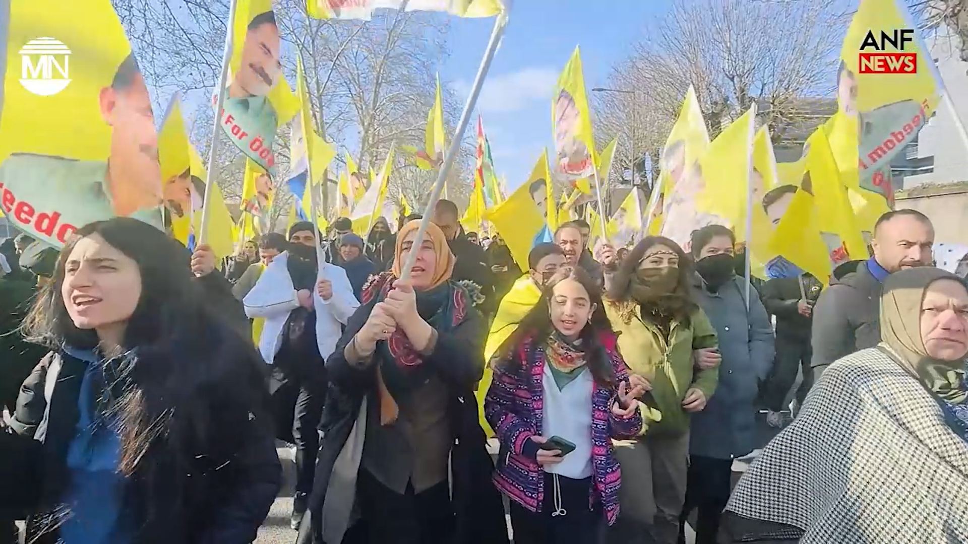 Das Bild zeigt eine Demonstration mit vielen Fahnen, auf denen ein Bild Öcalans zu sehen ist sowie der Forderung nach dessen Freilassung