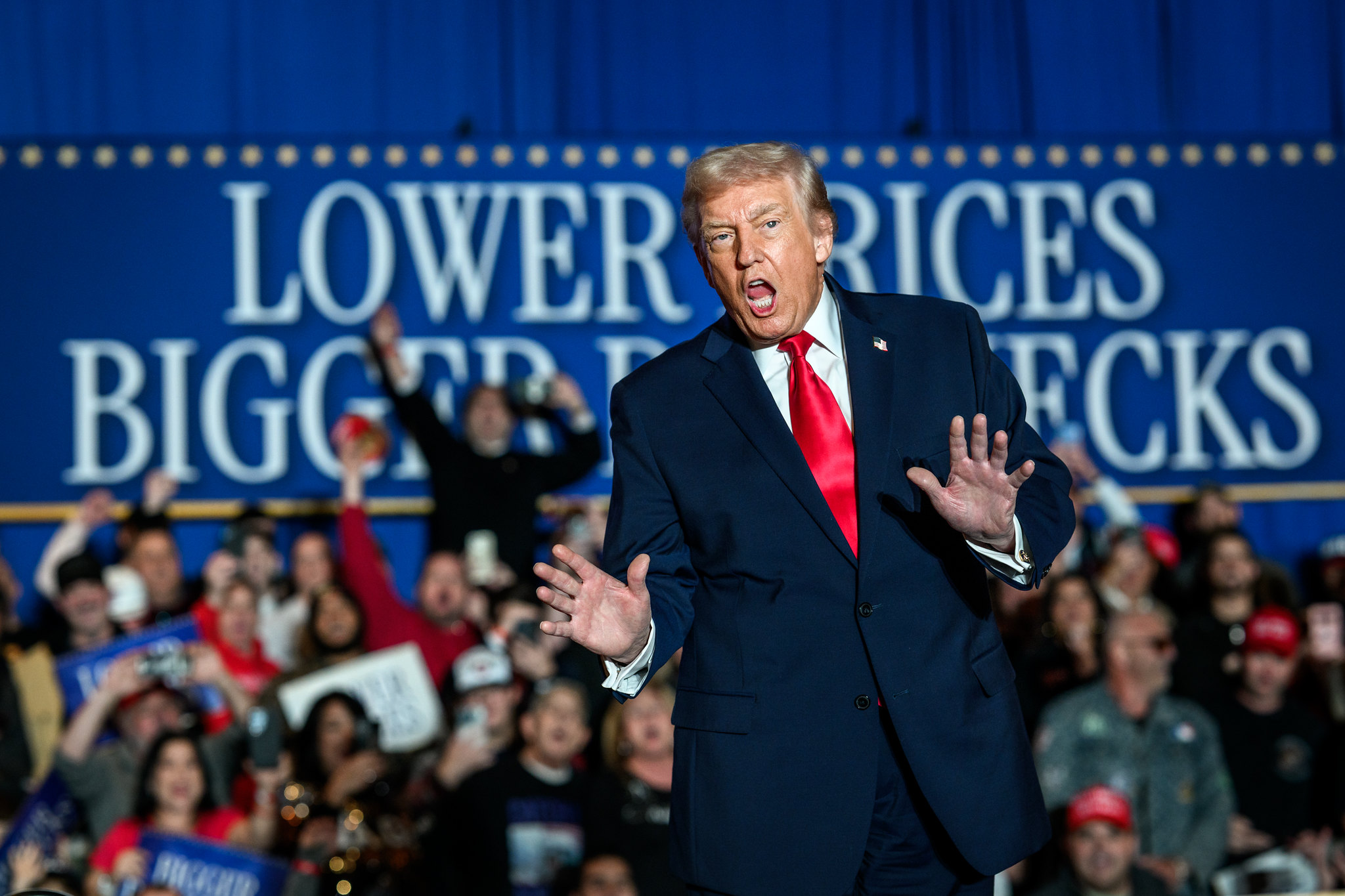 Das Foto zeigt den Präsidenten der USA bei einer Veranstaltung vor einem Transparent mit dem Text "Lower prices - bigger paychecks" ("Niedrigere Preise – höhere Gehälter") . Er verdeckt dabei das Wort "Paychecks"