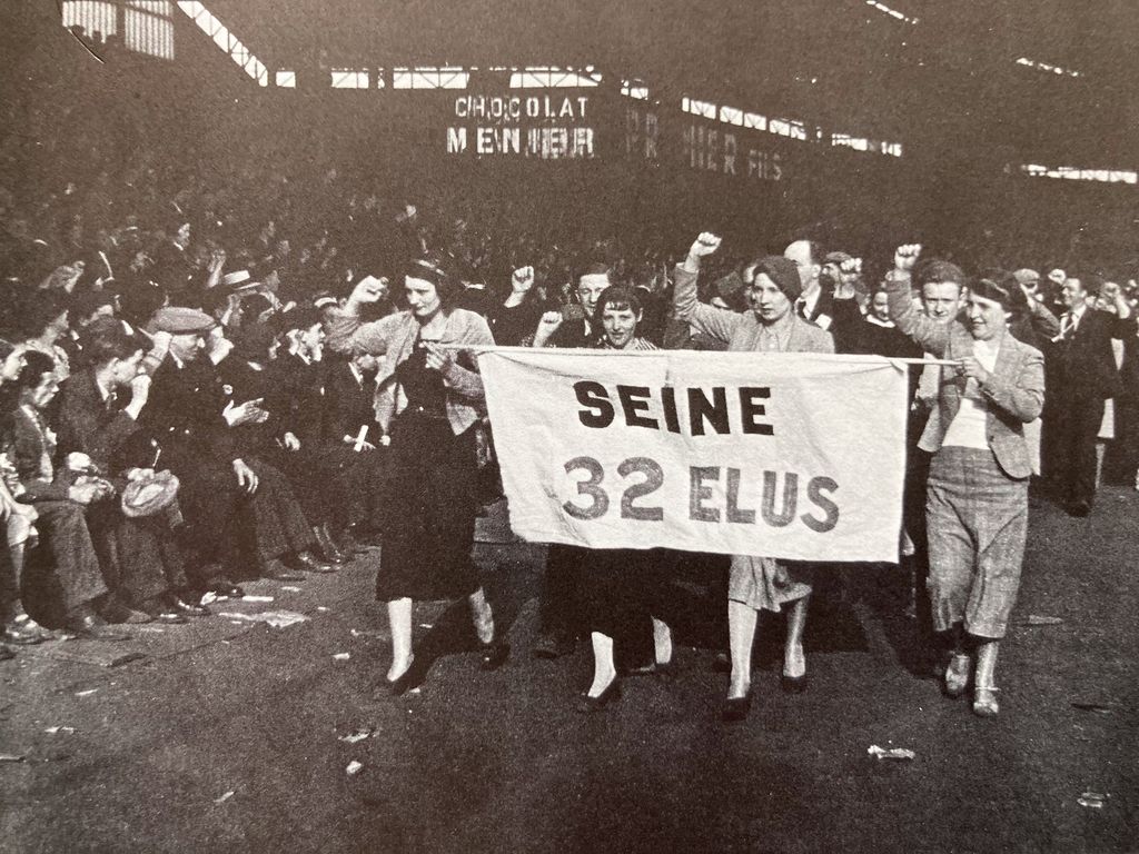 Das historische Foto zeigt die Szenerie einer Demonstration mit einem getragenen Transparent mit dem Text "Seine 32 elus"