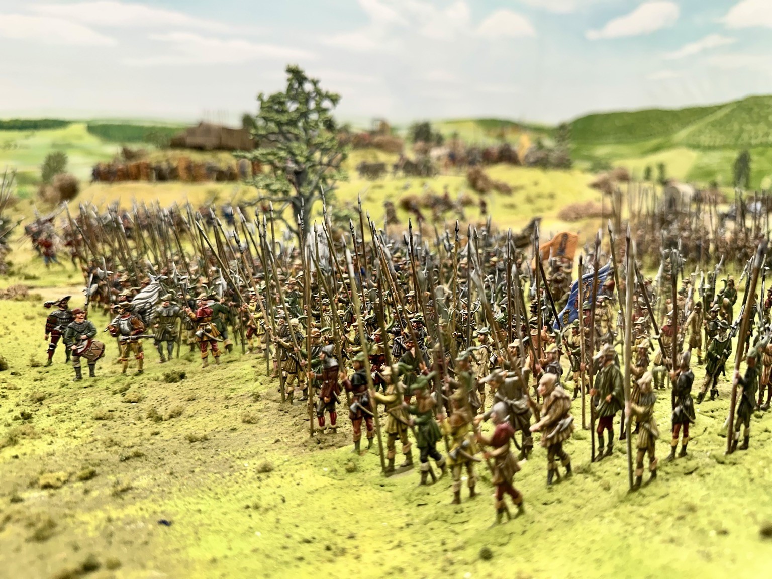 Das Foto zeigt einen kleinen Ausschnitt aus dem Diorama mit hunderten Zinnfiguren, hier bewaffnete Bauern in einer Ebene, mit einem Baum sowie den Hügeln des Schönbuchs im Hintergrund